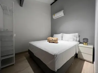 a small bedroom with a bed with a brown bag on it at Stylish 5-BR Apartment in Medellín's Trendiest Spot, Walk Everywhere! in Medellín