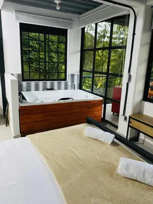 a large bathroom with a tub and a bed at Curazao Natural Living in Cocorná