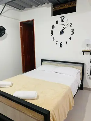 a bedroom with a bed with a clock on the wall at Curazao Natural Living in Cocorná