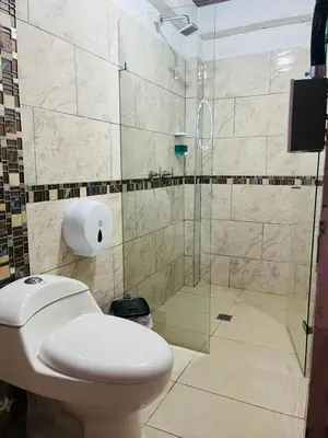 a bathroom with a toilet and a glass shower at Curazao Natural Living in Cocorná