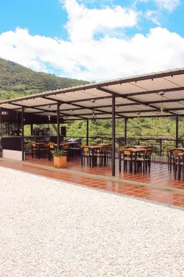 a pavilion with tables and chairs on a wooden deck at Curazao Natural Living in Cocorná