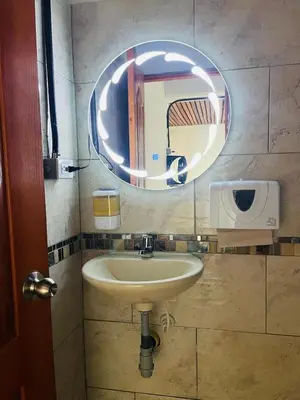 a bathroom with a sink and a round mirror at Curazao Natural Living in Cocorná