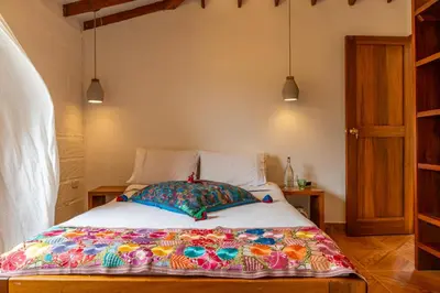 a bed with a colorful blanket on it in a room at Organic Finca with Modern Amenities in Jericó
