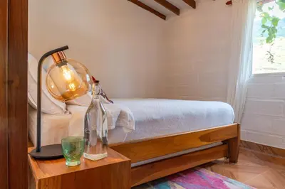 a bedroom with a bed and a table with a lamp at Organic Finca with Modern Amenities in Jericó