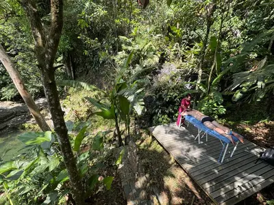 a person laying on a bench in the jungle at Cascadia in Cocorná