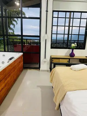 a bedroom with a bed and a bath tub and a window at Hotel Curazao Natural Living in Cocorná