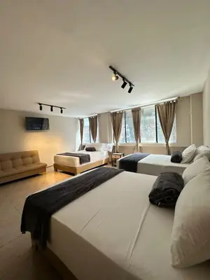 a large bedroom with two beds and a couch at Hotel Coral Boutique in Medellín