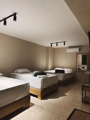 a bedroom with two beds and a tv in it at Hotel Coral Boutique in Medellín