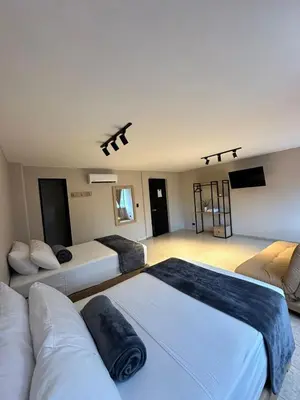 a living room with two beds and a couch at Hotel Coral Boutique in Medellín