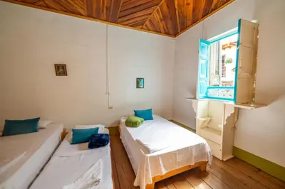 a room with two beds and a window at Casa Hotel Santa Laura Jericó in Jericó
