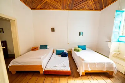 two beds in a room with wooden floors at Casa Hotel Santa Laura Jericó in Jericó