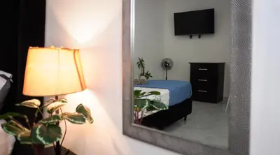 a mirror in a room with a bed and a lamp at Casa MoraZ in Medellín