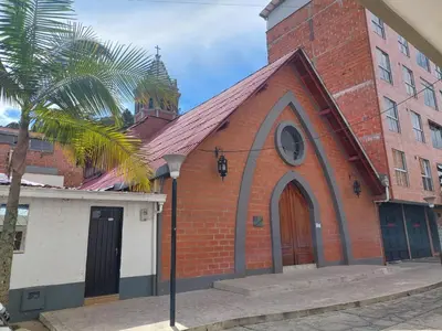 a red brick church with a clock on it at San Antonio in El Peñol