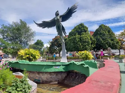 a statue of a woman with her wings out on a bridge at San Antonio in El Peñol