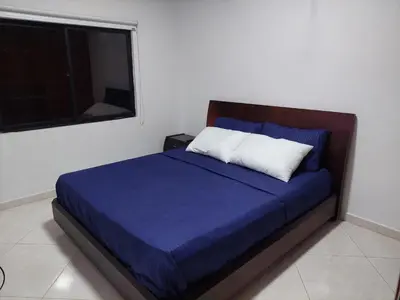 a bedroom with a blue bed with a window at San Antonio in El Peñol