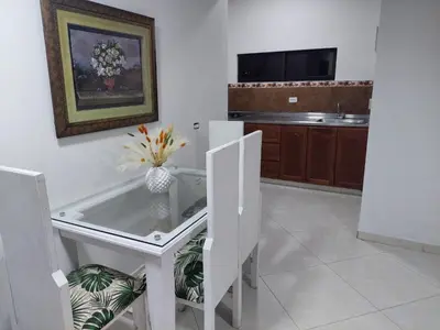 a kitchen with a glass table with a vase of flowers at San Antonio in El Peñol