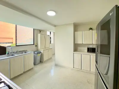 a kitchen with white cabinets and a sink and a refrigerator at 4BR 240 m² Pool Next to El Tesoro Mall in Medellín