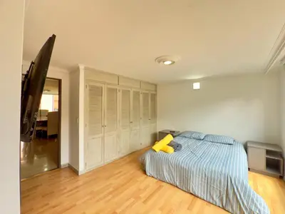 a bedroom with a bed with a yellow pillow on it at 4BR 240 m² Pool Next to El Tesoro Mall in Medellín