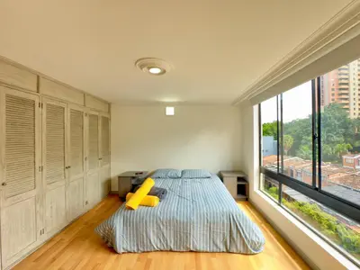 a bedroom with a bed and a large window at 4BR 240 m² Pool Next to El Tesoro Mall in Medellín