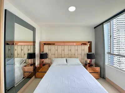 a bedroom with a large white bed and two lamps at 3BR Panoramic Near Country Club El Poblado in Medellín