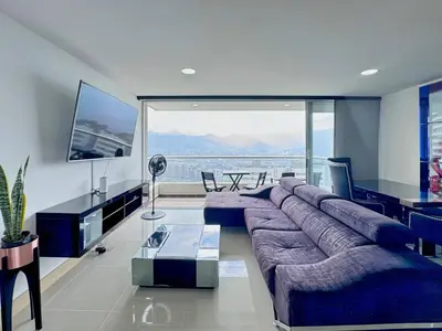 a living room with a large couch and a large window at 3BR Panoramic Near Country Club El Poblado in Medellín