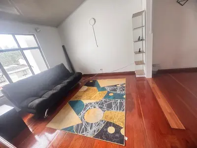 a living room with a couch and a rug at Urbanhost in Manizales