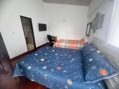 a bedroom with a bed with a blue sheet at Urbanhost in Manizales