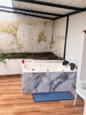 a bath tub in a room with a wall at Urbanhost in Manizales