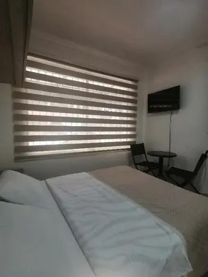 a bedroom with a large white bed and a window at Apartamento Aeropuerto Rionegro in Rionegro