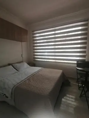a bedroom with a bed and a window with blinds at Apartamento Aeropuerto Rionegro in Rionegro