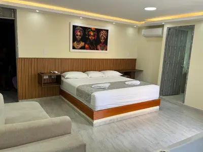 a bedroom with a bed with a picture on the wall at Hotel Magistral Suiter in Quibdó