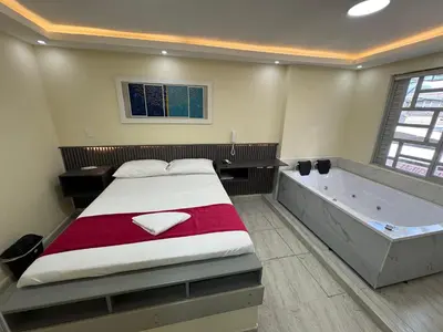 a bedroom with a bed and a bath tub at Hotel Magistral Suiter in Quibdó