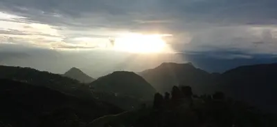 a view of the sun shining over the mountains at Kcafe Ancestral Glamping in Venecia