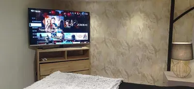 a bedroom with a tv on a wall with a bed at Kcafe Ancestral Glamping in Venecia