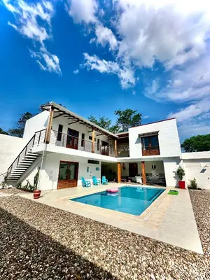 a house with a swimming pool in front of it at Villa Paulina in Honda