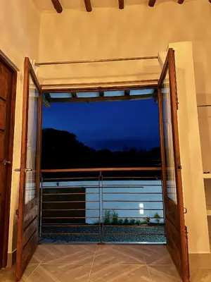 an open door to a balcony with a view of the ocean at Villa Paulina in Honda
