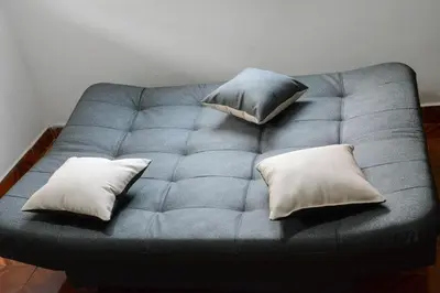 a blue couch with three pillows on it at Apto Acogedor Cerca Metrocable in Medellín