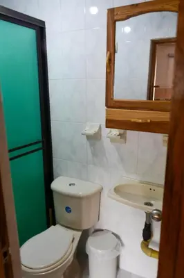 a bathroom with a toilet and a sink and a mirror at Apto Acogedor Cerca Metrocable in Medellín