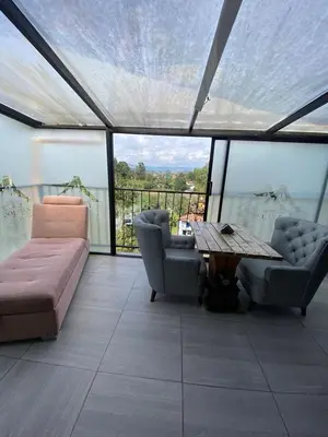 a living room with couches and a table and windows at Hotel Volcán Campestre Guatapé in Guatapé