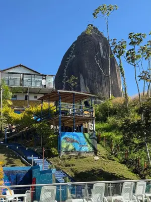 a view of a resort with a rock in the background at Hotel Volcán Campestre Guatapé in Guatapé