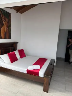 a bed with red and white pillows in a room at Hotel Volcán Campestre Guatapé in Guatapé