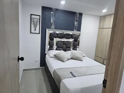 a bedroom with a bed with white sheets and pillows at 201New apartment perfect location Close to poblado in Medellín