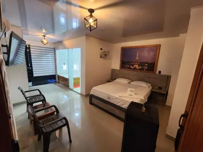 a bedroom with a bed and a chair in it at Hotel tranquilandia La 14 in La Dorada