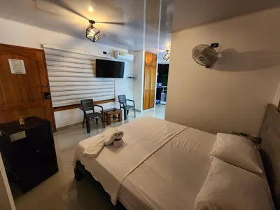 a bedroom with a bed and a table with chairs at Hotel tranquilandia La 14 in La Dorada