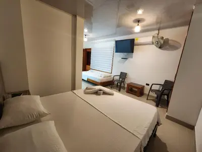 a hotel room with two beds and a television at Hotel tranquilandia La 14 in La Dorada