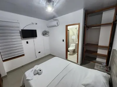 a bedroom with a bed and a bathroom with a toilet at Hotel tranquilandia La 14 in La Dorada