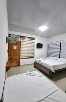 a bedroom with two beds and a television in it at Hotel tranquilandia La 14 in La Dorada