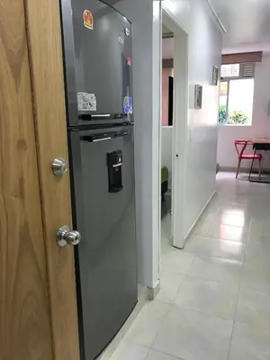 a refrigerator in a hallway next to a door at Apartamentos Amoblados JG de la 70 in Medellín