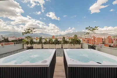 two hot tubs on the roof of a building at Quadrato Studios in Medellín