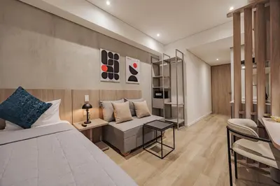 a bedroom with a bed and a couch and a table at Quadrato Studios in Medellín